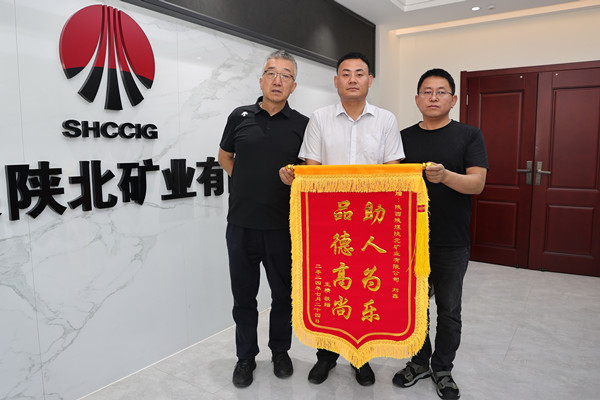 图为：刘鑫（中）接管锦旗.JPG